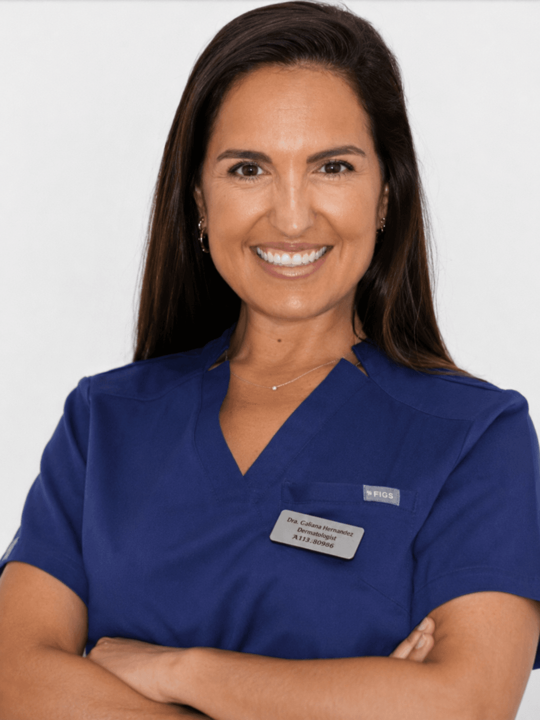 Retrato profesional de la Dra. Cristina Izquierdo Orts, especialista en ortodoncia e Invisalign, con uniforme clínico azul