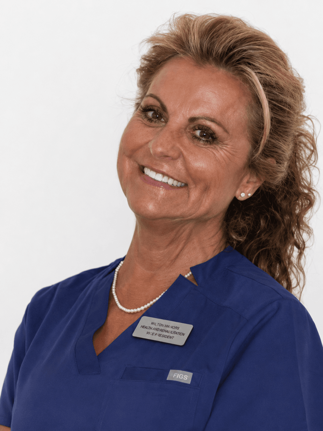 Retrato profesional de la Dra. Mª Teresa Orts Rodríguez, fundadora y directora médica de Clínica Dental Arosa, con uniforme clínico azul